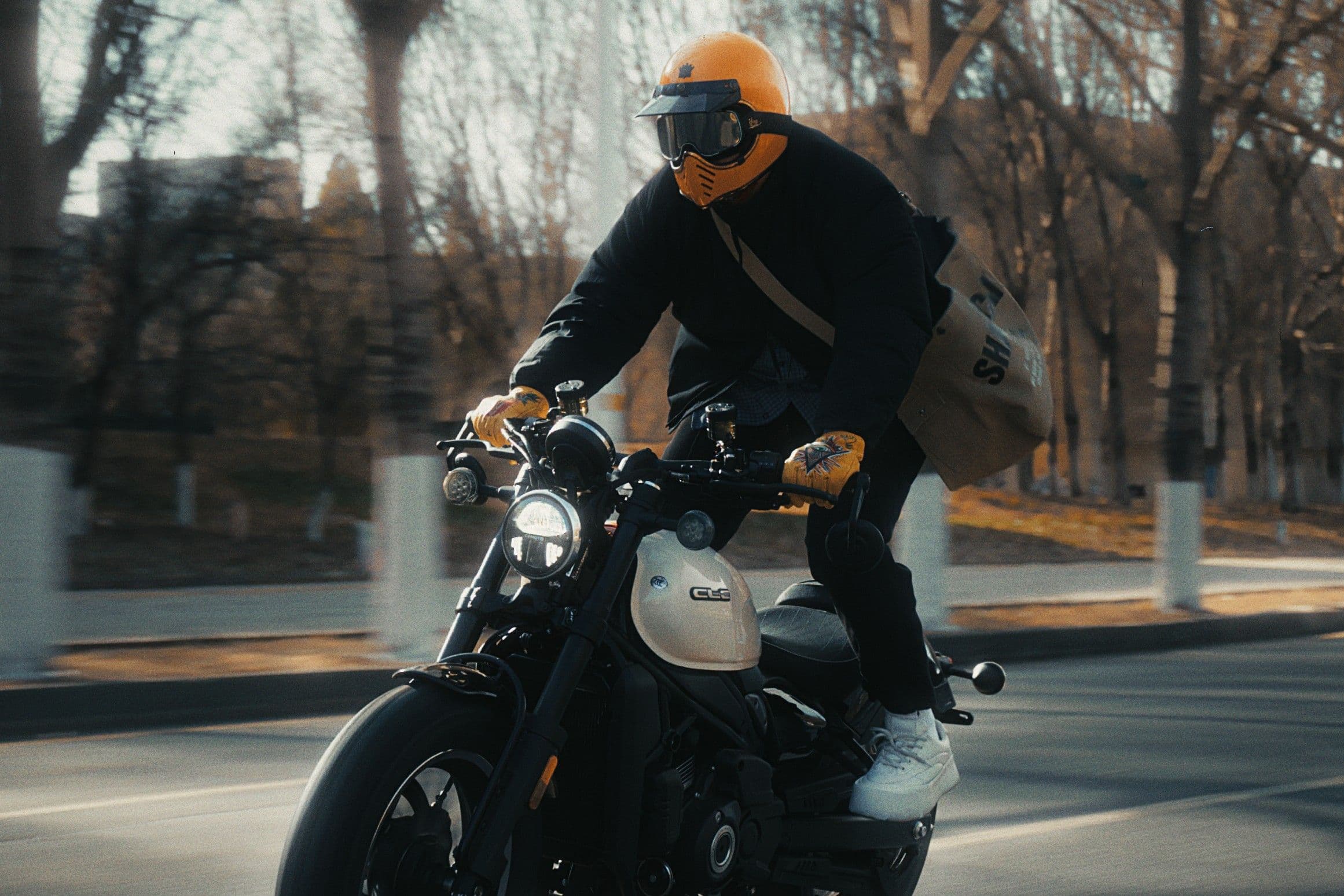 Rider in yellow helmet and goggles on a black motorcycle, mid-ride.